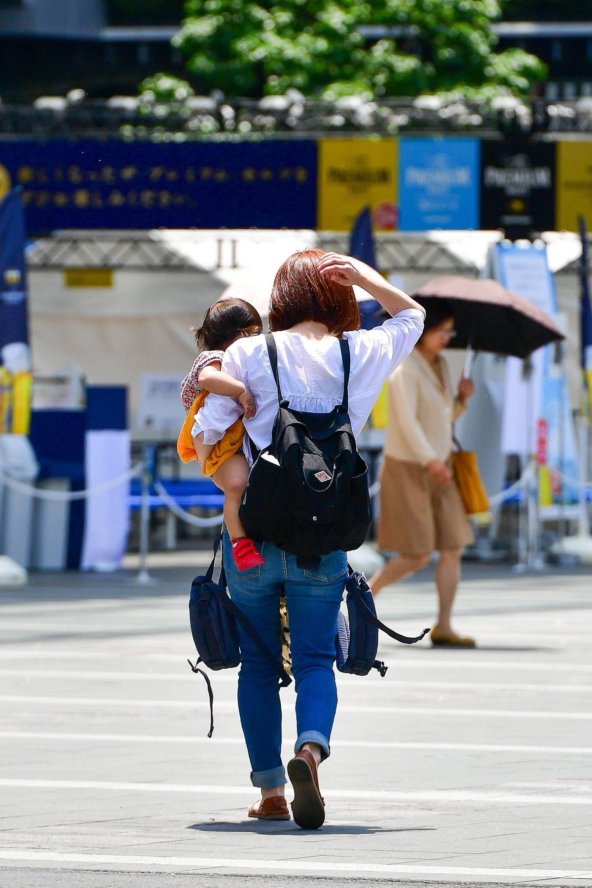 街なかで子どもを抱いて歩くお母さん